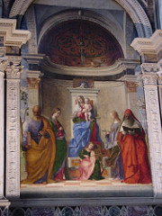 San Zaccaria Altarpiece by Bellini, Venetian 
- Madonnas in half-length, large altarpiece
- holy conversation, refined compositional elements
- virgin w/child in center
- st peter w/key and book
- st catherine - palm and wheel
- st jerome - just book translation bible
- angel playing viol in center, placed inside of a shrine, peeks out to outdoor lighting
- architecture receeding into architecture, creates apse behind flat wall, frames scene
-serenity created with colors, little interaction between figures, lines dissolve, atmospheric haziness, like sfumato
- play on depth of space
- floor = recession into space